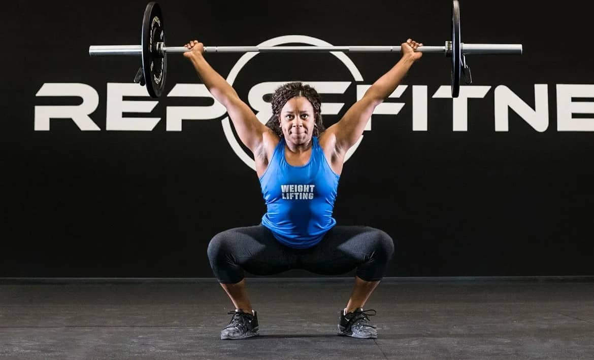 Rep Fitness Rep Black Bumper Plates with an athlete