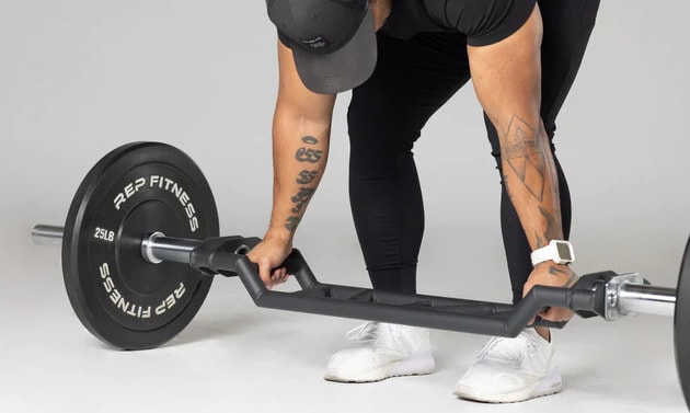 Rep Fitness Cambered Swiss Bar with a user 3