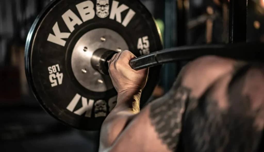 Rogue Fitness Kabuki Strength Duffalo Bar with an athlete 1