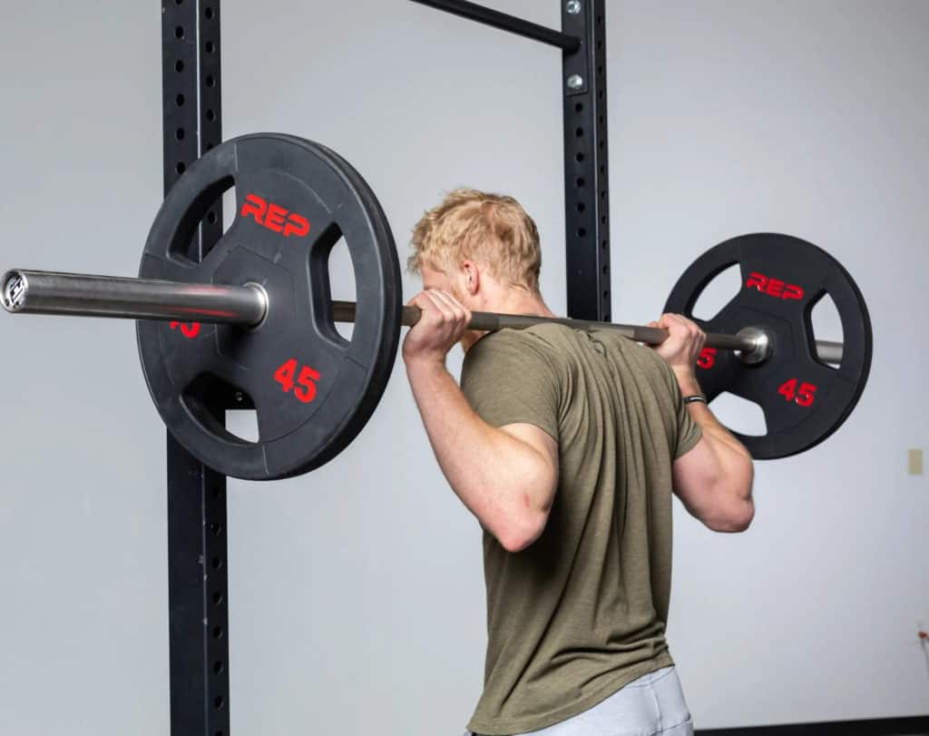 Rep Fitness Rubber Coated Olympic Plates with an athlete